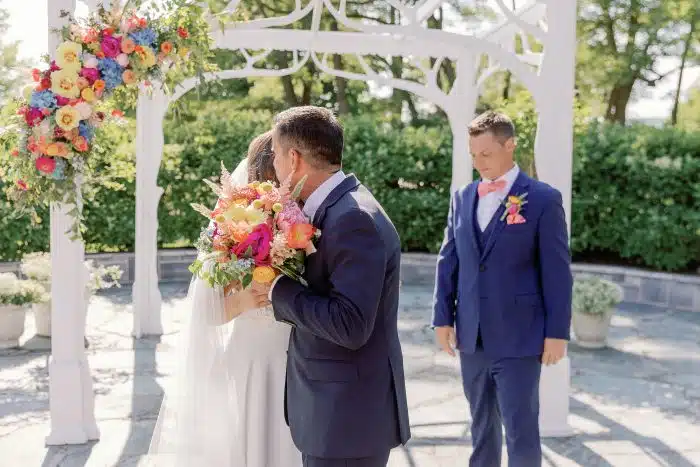 Couple and Father of Bride at Wedding Ceremony at Wedding Arch