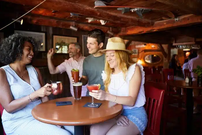 Group at the hightop area at The Red Mill having drinks and playing darts