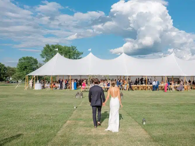 A bride and groom walking in to their wedding reception