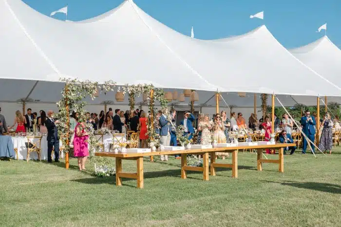 A wedding reception under a large white tent by the waterfront