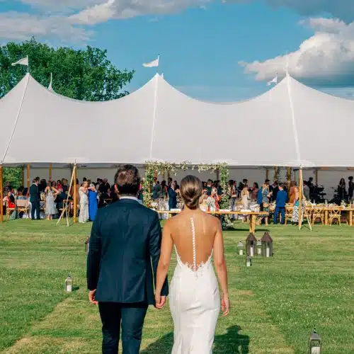A bride and groom walking in to their wedding reception