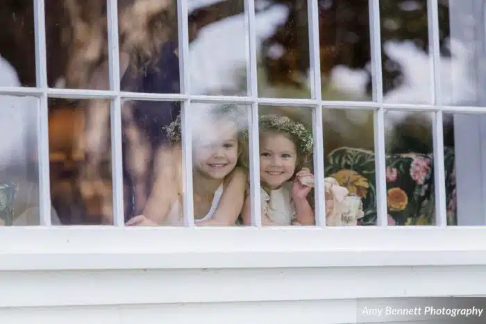 Two young girls looking out a window