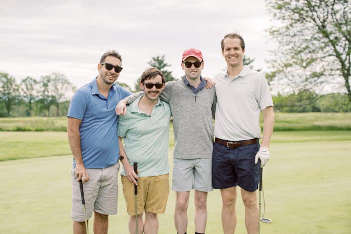 Group of men posing for a photo during their golf game.