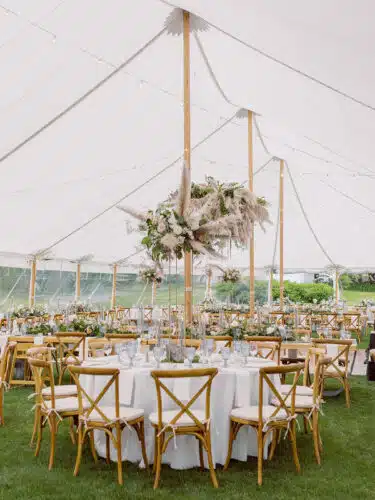 A wedding reception set up under a white wedding tent