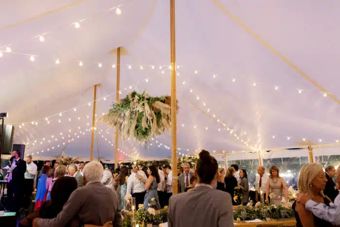 A wedding reception under a white wedding tent