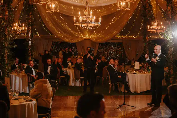 A person giving a speech at a wedding reception