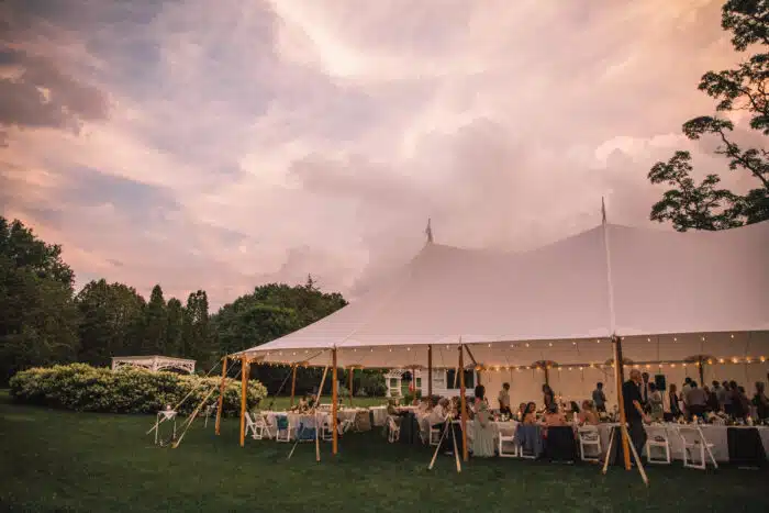 A wedding reception under a white wedding tent