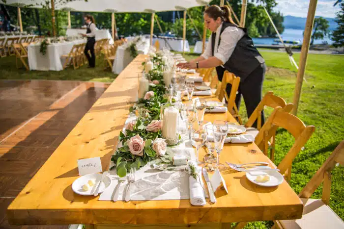 A Basin Harbor staff member setting up a table for a wedding reception