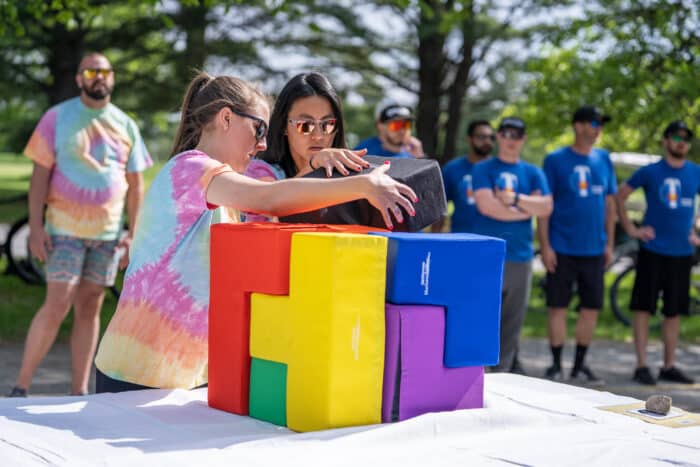 Logic challenge part of team building at Basin Harbor. Two women uses colorful cube pieces to form a completed cube.
