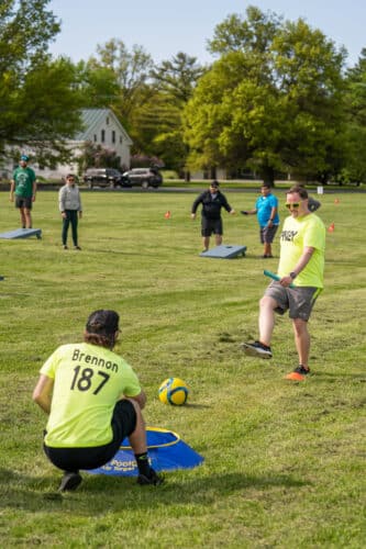 A group playing a variety of lawn games as team building.