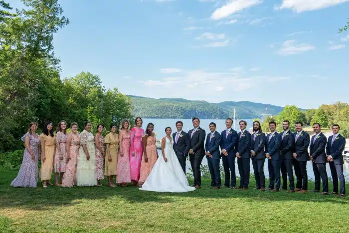 The bride and groom with their wedding party in front of the lake