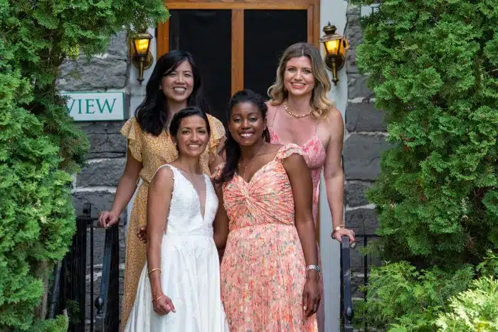 A bride with some wedding guests in front of an accommodation