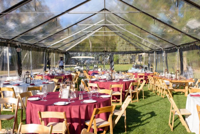 A clear wedding tent set up for a wedding reception.